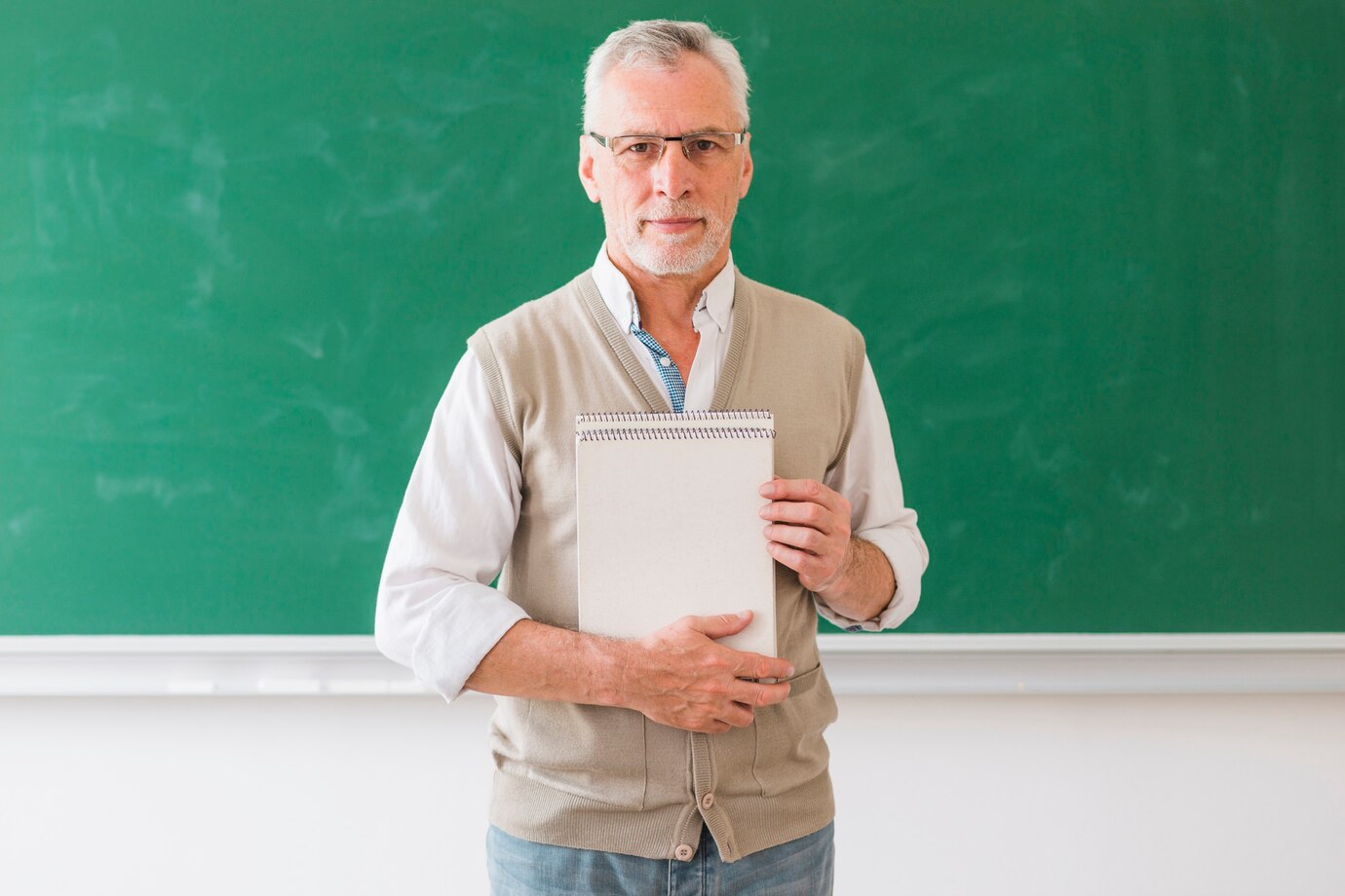 senior-male-professor-holding-notebook-standing-against-blackboard_23-2148200961.jpg